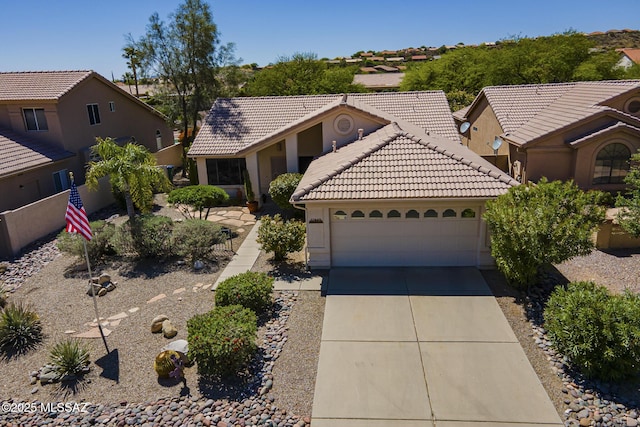 view of front of home featuring stucco siding, a tile roof, driveway, and a garage