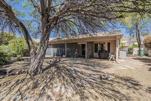 rear view of property with stucco siding and a sunroom