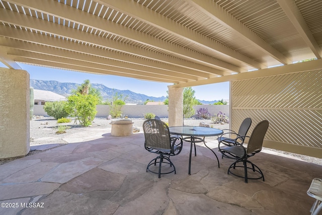 view of patio with a fenced backyard, outdoor dining area, and a mountain view