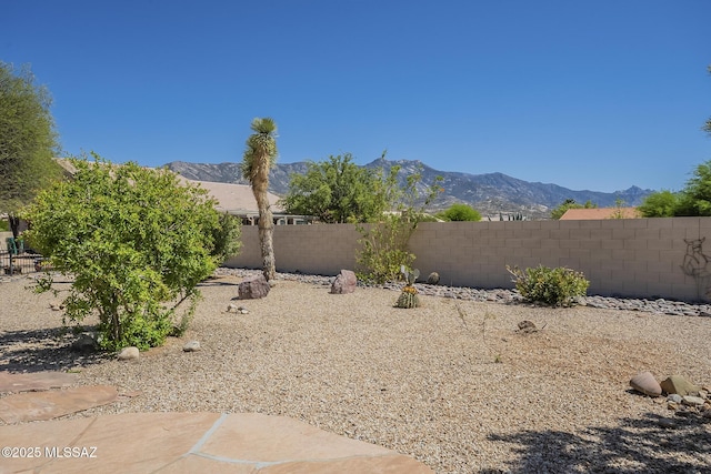 view of yard featuring fence and a mountain view