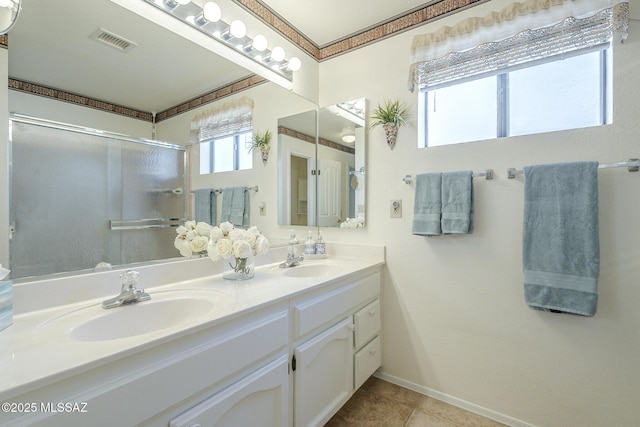 bathroom with double vanity, a sink, visible vents, and a stall shower