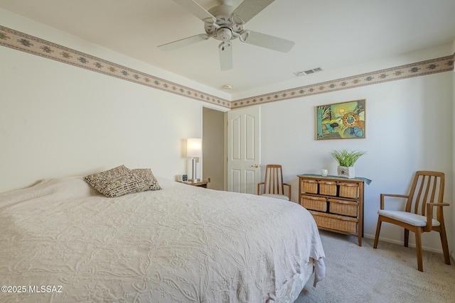 carpeted bedroom featuring baseboards, a ceiling fan, and visible vents