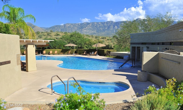pool with a mountain view, fence, and a patio area
