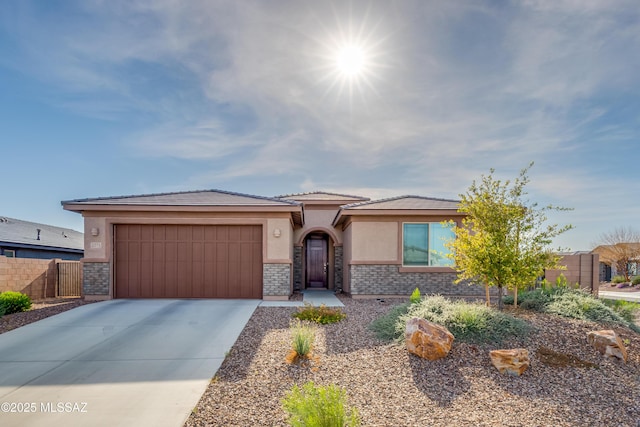 prairie-style house featuring driveway, a garage, brick siding, fence, and stucco siding