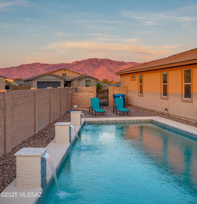 view of swimming pool with a fenced backyard, a fenced in pool, a mountain view, and a patio