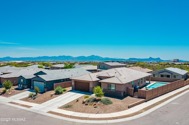 2271 W Azure Creek Loop, Tucson, AZ 85742 - view of front of house featuring a garage, concrete driveway, a residential view, a mountain view, and stucco siding