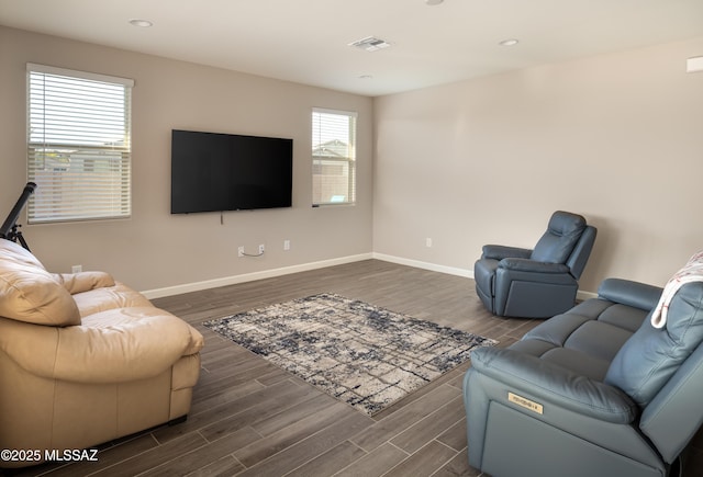 living room with dark wood-style flooring, baseboards, and visible vents