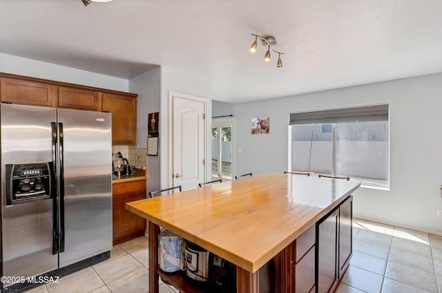 5273 W Fireopal Way, Tucson, AZ 85742 - kitchen with stainless steel fridge with ice dispenser, brown cabinetry, light tile patterned flooring, wood counters, and backsplash