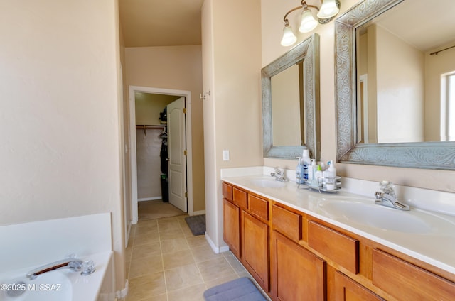 5273 W Fireopal Way, Tucson, AZ 85742 - bathroom featuring tile patterned floors, a walk in closet, double vanity, and a sink