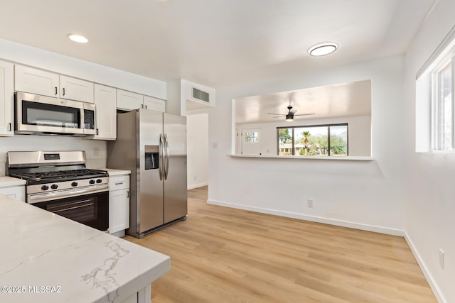 kitchen with visible vents, baseboards, ceiling fan, light wood-type flooring, and stainless steel appliances
