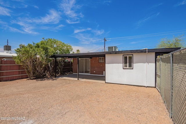 rear view of house with a patio, brick siding, and a fenced backyard