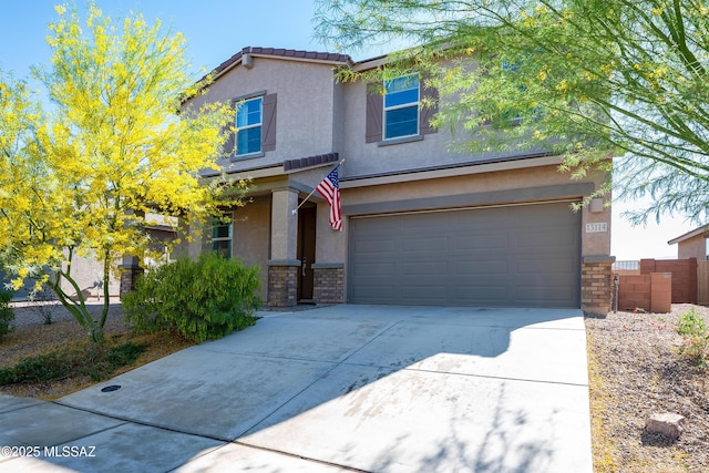 traditional home featuring an attached garage, stone siding, concrete driveway, and stucco siding