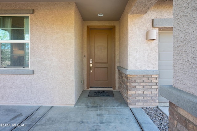 entrance to property with stone siding and stucco siding