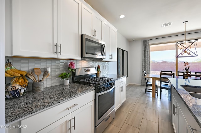 kitchen with baseboards, white cabinetry, appliances with stainless steel finishes, and tasteful backsplash