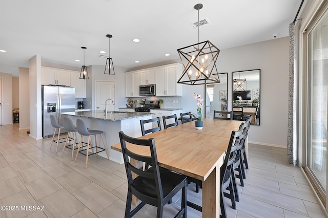 dining room featuring baseboards, visible vents, and recessed lighting