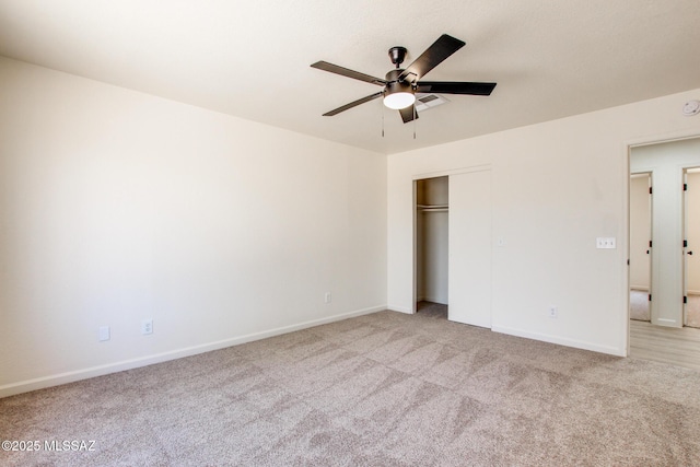 unfurnished bedroom featuring light carpet, baseboards, and a closet