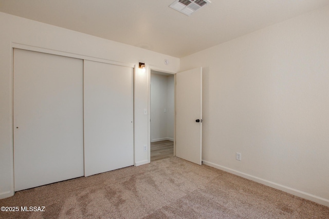 unfurnished bedroom featuring carpet floors, a closet, and baseboards
