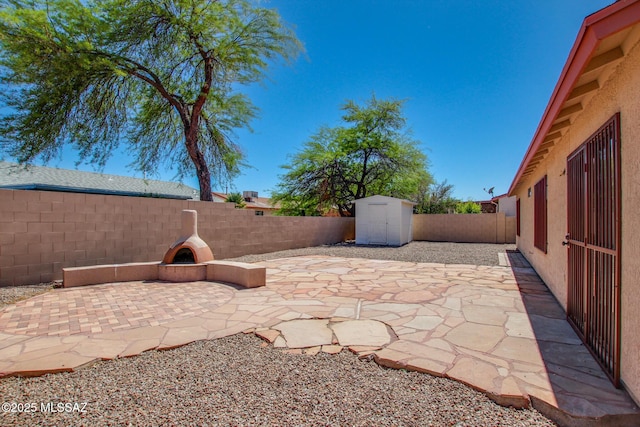 view of patio / terrace with a fenced backyard, a storage shed, and an outdoor structure