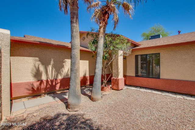 back of house with stucco siding and a patio area