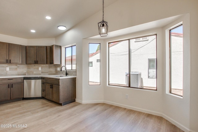 kitchen featuring stainless steel dishwasher, a sink, light countertops, plenty of natural light, and recessed lighting