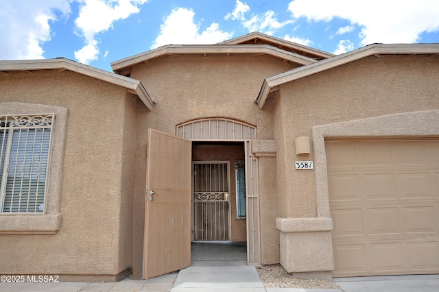 3581 W Avenida Vera Cruz, Tucson, AZ 85746 - doorway to property featuring stucco siding, a gate, and a garage