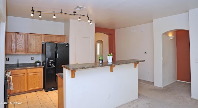 3581 W Avenida Vera Cruz, Tucson, AZ 85746 - kitchen featuring black fridge, dark countertops, stainless steel gas stove, and a kitchen breakfast bar