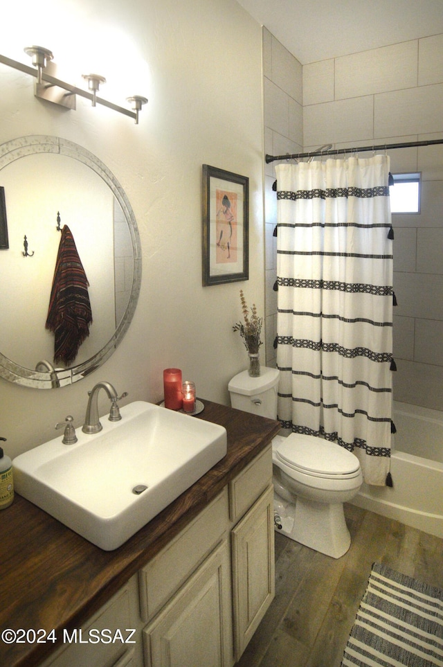 bathroom featuring toilet, shower / bathtub combination with curtain, wood finished floors, and vanity