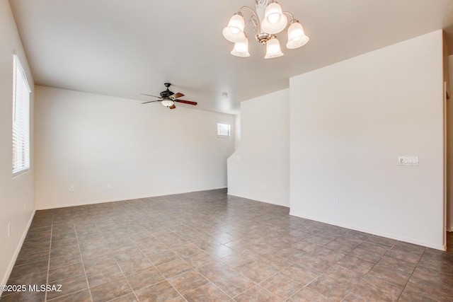 empty room featuring baseboards, a wealth of natural light, and ceiling fan with notable chandelier