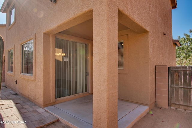 exterior space with a patio area, stucco siding, and fence