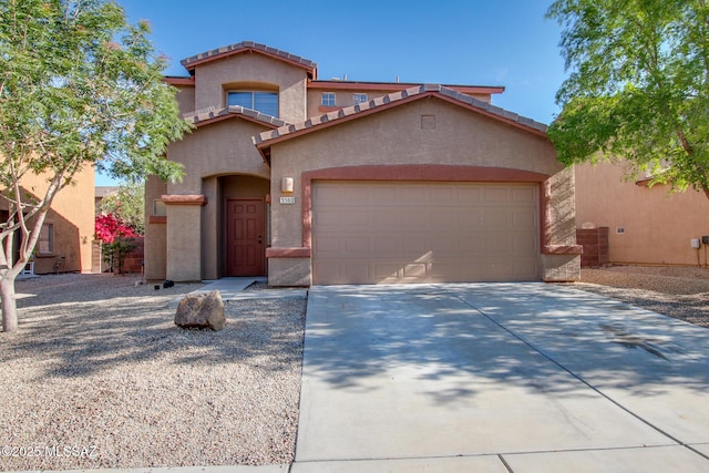 mediterranean / spanish house featuring stucco siding, an attached garage, and driveway