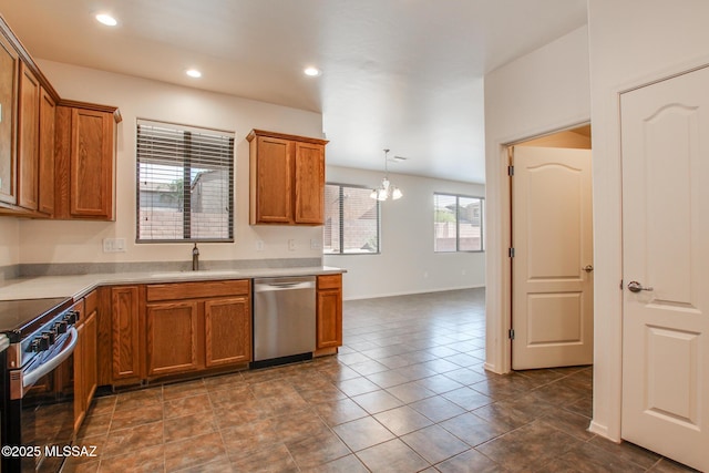 kitchen with brown cabinets, baseboards, appliances with stainless steel finishes, and a sink