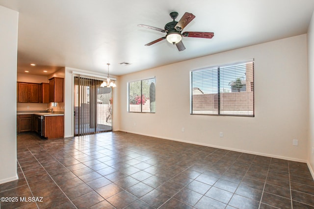 unfurnished living room featuring ceiling fan with notable chandelier, baseboards, visible vents, and recessed lighting