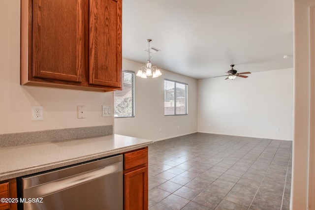 kitchen with brown cabinets, light countertops, dishwasher, light tile patterned flooring, and ceiling fan with notable chandelier