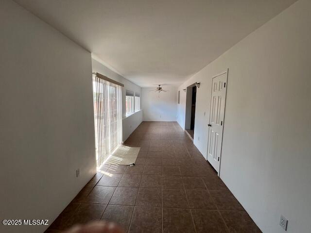 hall featuring dark tile patterned flooring