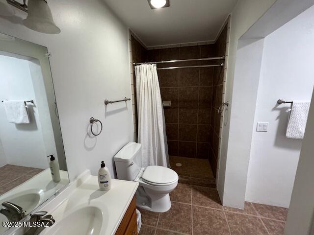 full bath with tile patterned floors, toilet, a tile shower, and vanity