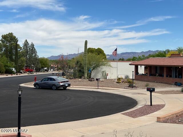 view of street with street lighting, sidewalks, a mountain view, and curbs