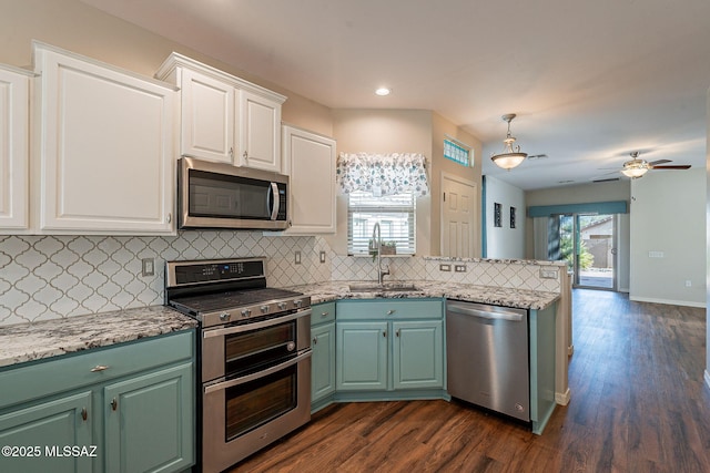 kitchen featuring a sink, tasteful backsplash, appliances with stainless steel finishes, and white cabinets
