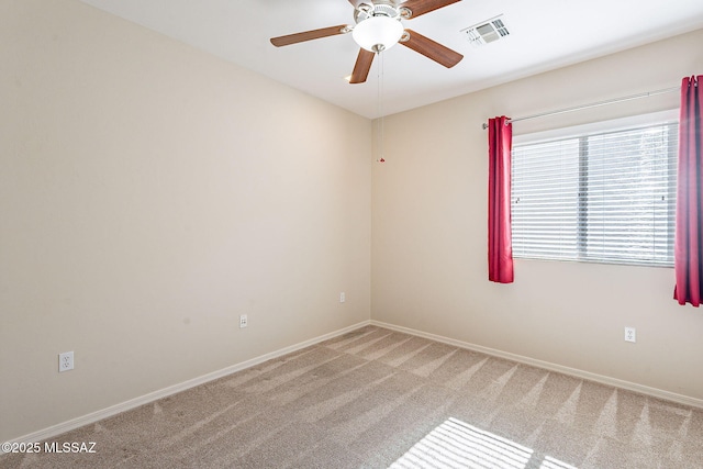 empty room with baseboards, light colored carpet, ceiling fan, and visible vents