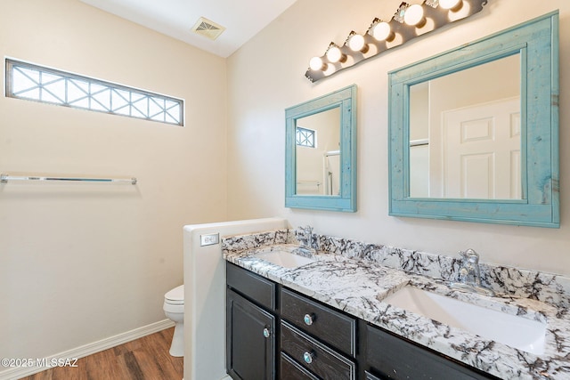 bathroom featuring visible vents, a sink, toilet, and wood finished floors