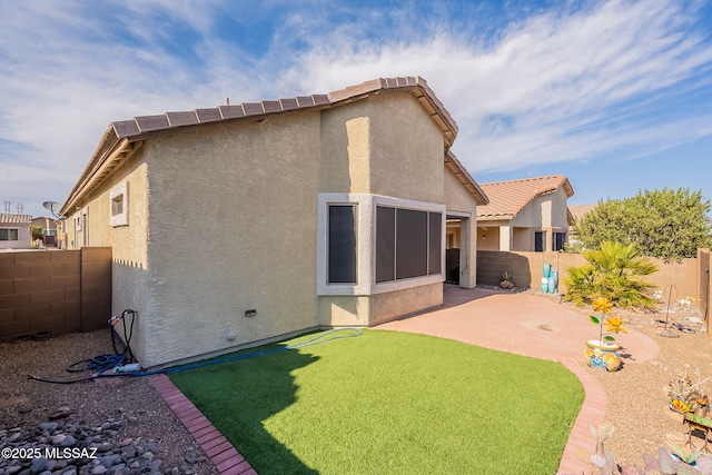 back of property featuring a patio area, stucco siding, a fenced backyard, and a tile roof