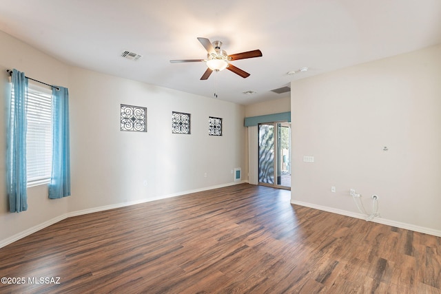 spare room with visible vents, ceiling fan, wood finished floors, and baseboards