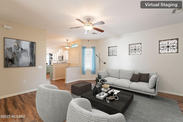 living area with visible vents, wood finished floors, and ceiling fan