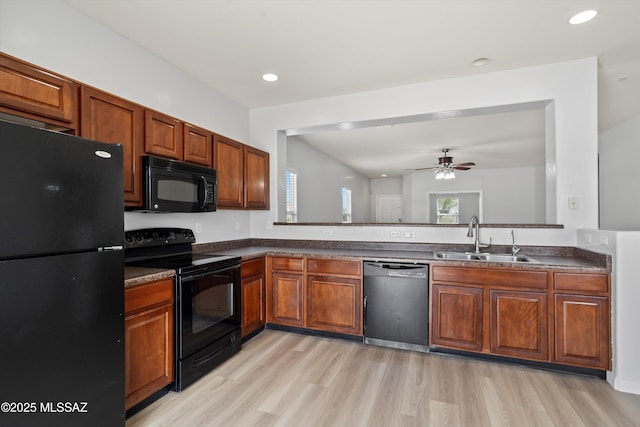 21700 E Governor Dr, Red Rock, AZ 85145 - kitchen with light wood-style flooring, a sink, black appliances, and dark countertops