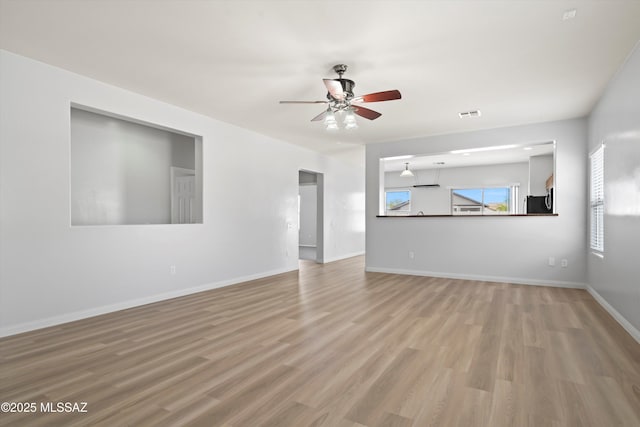 21700 E Governor Dr, Red Rock, AZ 85145 - unfurnished living room with visible vents, baseboards, wood finished floors, and ceiling fan