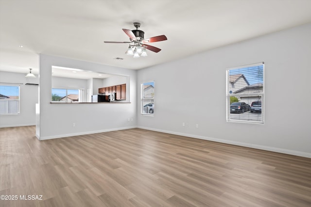 21700 E Governor Dr, Red Rock, AZ 85145 - unfurnished living room featuring baseboards, a ceiling fan, and light wood-style floors