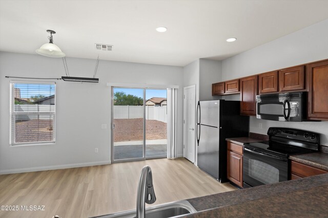 21700 E Governor Dr, Red Rock, AZ 85145 - kitchen with visible vents, dark countertops, black appliances, recessed lighting, and light wood-style flooring