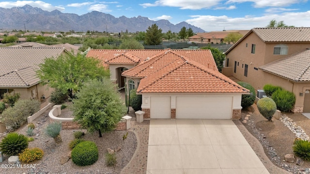 62235 E Sandlewood Rd, Tucson, AZ 85739 - mediterranean / spanish-style house with stone siding, an attached garage, stucco siding, concrete driveway, and a tiled roof