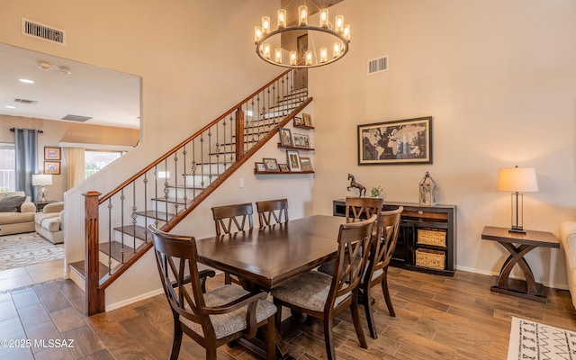 9125 S Crows Nest Ct, Tucson, AZ 85756 - dining room featuring a towering ceiling, stairway, a chandelier, baseboards, and wood finished floors