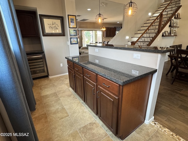 9125 S Crows Nest Ct, Tucson, AZ 85756 - kitchen featuring wine cooler, a center island, baseboards, dark stone countertops, and hanging light fixtures