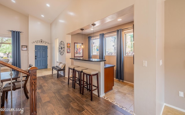 9125 S Crows Nest Ct, Tucson, AZ 85756 - kitchen with a breakfast bar area, healthy amount of natural light, dark countertops, recessed lighting, and decorative light fixtures